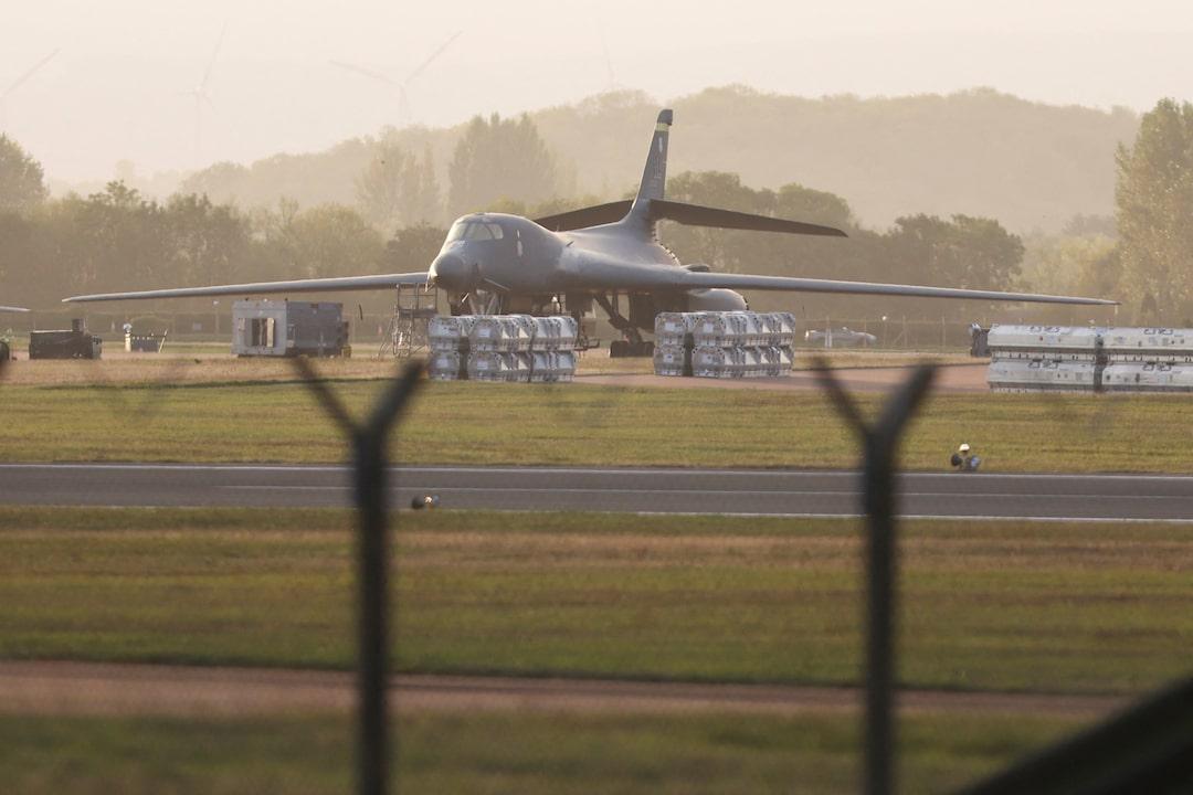 A B-1 bomber on the RAF Fairford ramp with munitions stacked nearby