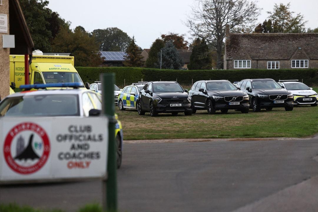 Police cars and an ambulance staged on the grass at Fairford Youth Football Club
